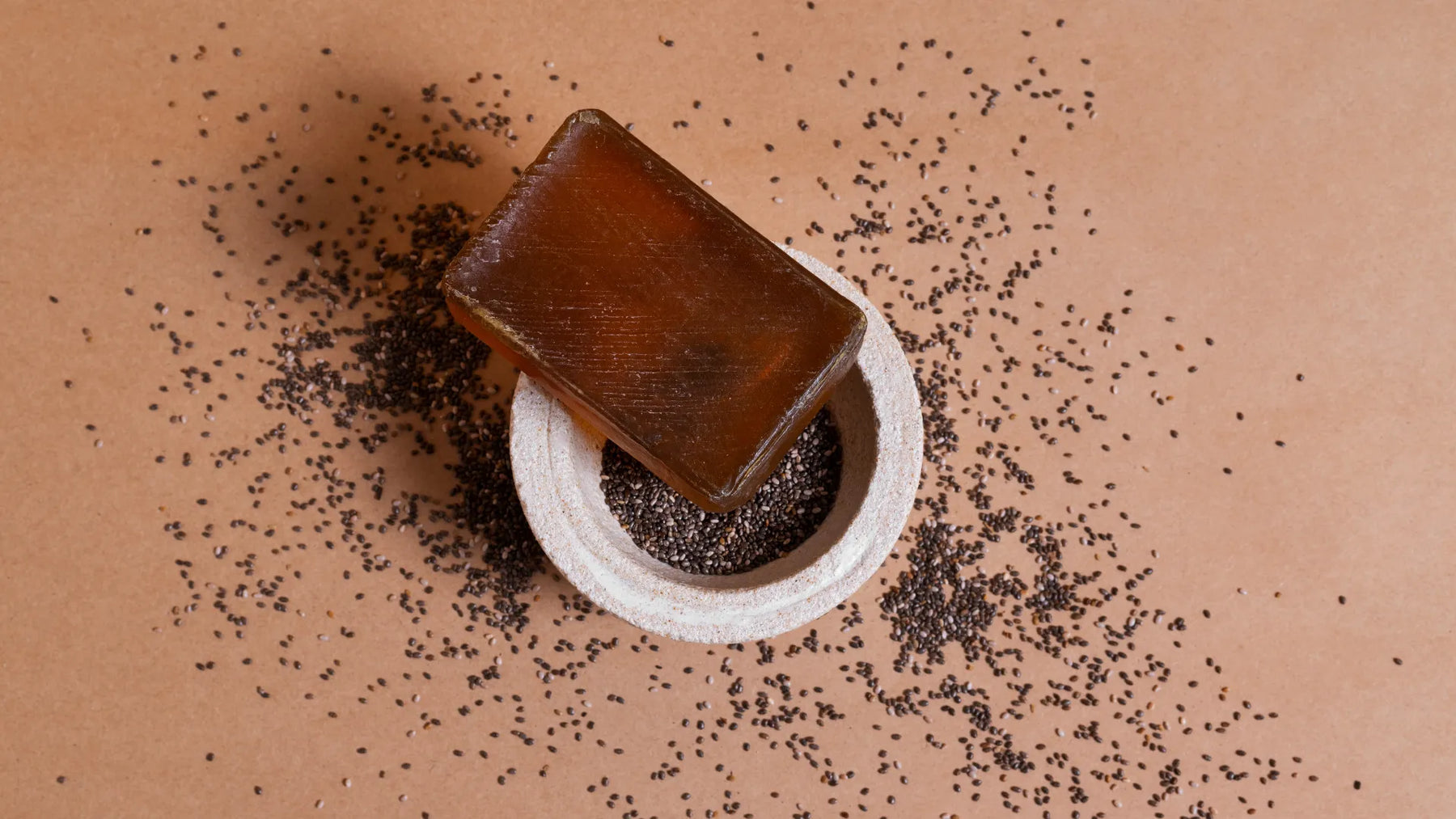 Handmade coffee and cocoa exfoliating soap bar displayed on a bowl with natural exfoliating ingredients.
