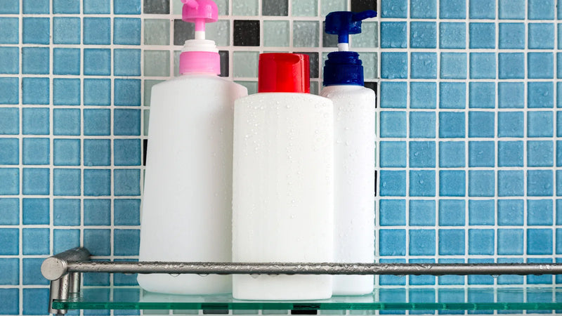 Shampoo and conditioner bottles with water droplets on a shower shelf, illustrating what a CPSR safety assessor checks for hair care