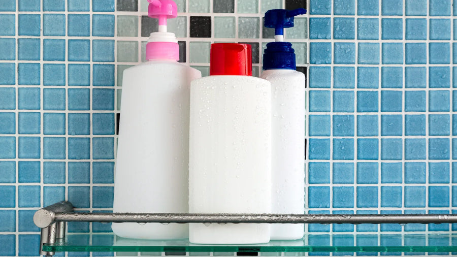 Shampoo and conditioner bottles with water droplets on a shower shelf, illustrating what a CPSR safety assessor checks for hair care